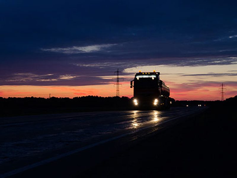 Camión circulando por autopista de noche con servicio 24 horas